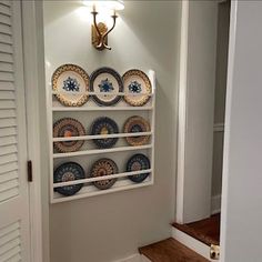 plates are displayed on the wall in this entry way