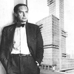 an old photo of a man standing in front of a poster with buildings on it