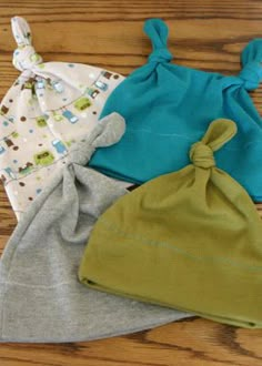 three baby hats sitting on top of a wooden floor