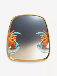 a mirror with two hands holding something in each hand and the reflection of another person's hand