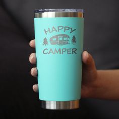 a person holding a cup with the words happy camper on it