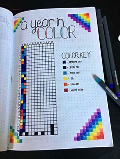 an open planner with colored pencils on top of it and the text, a year in color