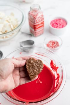 someone is holding a heart shaped cookie in their hand