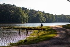 a dirt road next to a body of water