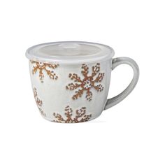 a white cup with gold snowflakes on it and a lid in the shape of a mug