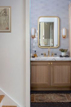 a bathroom with two sinks and a large mirror on the wall next to some stairs