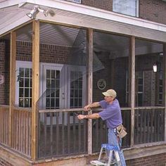 a man standing on a stepladder painting the outside of a house's porch