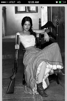 black and white photograph of a woman sitting on a chair with an umbrella in her hand