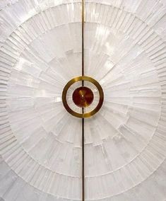 a large white umbrella with gold trim around it's edges and an orange circle at the center