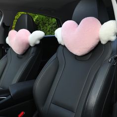 two pink and white heart shaped pillows in the back seat of a car