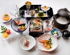 a table topped with plates and bowls filled with different types of food on top of it