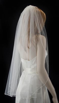 a woman wearing a white veil and wedding dress