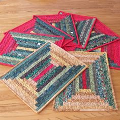 four quilted placemats sitting on top of a wooden table