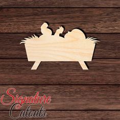 a wooden cutout of two people in a manger with the words signature cuts