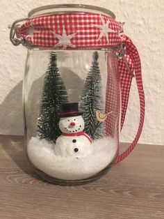 a snowman in a jar with trees inside