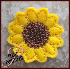 a close up of a yellow and brown flower on a gray surface with the words posh peanuts written below it