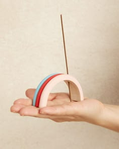 a person holding something in their hand with a toothpick stuck to the top