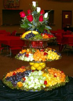 three tiered trays filled with fruit and flowers