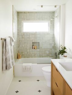 a bathroom with a sink, toilet and bathtub in it's center area