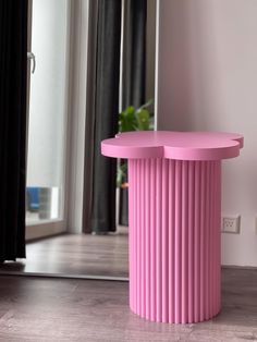 a pink table sitting in front of a mirror