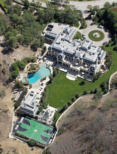 an aerial view of the house and its surrounding grounds, including a tennis court in the foreground