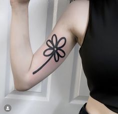 a woman's arm with a flower tattoo on the left side of her arm