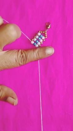 a hand holding a string with beads on it