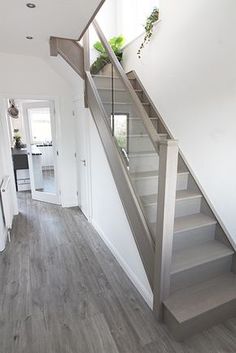 a staircase leading up to the second floor in a house with white walls and wood floors