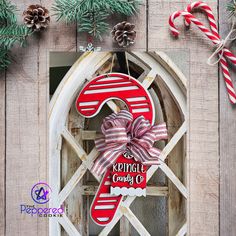 a red and white christmas ornament hanging from a window with candy canes