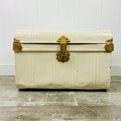 an old white suitcase sitting on the floor