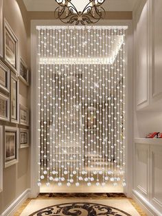 a hallway with a chandelier hanging from the ceiling and pictures on the wall