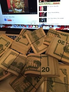 stacks of twenty dollar bills sitting in front of a computer screen