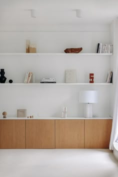 an empty room with white walls and shelves