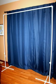 an image of a blue curtain with white poles in front of it and on the floor