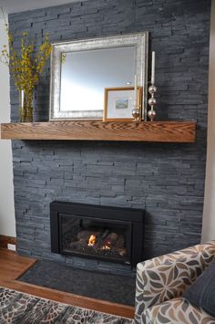 a fire place with a mirror above it