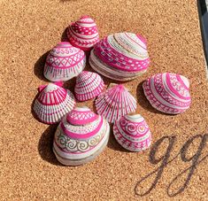 several pink and white seashells sitting on top of a cork board