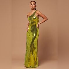 a woman in a green sequin gown posing for the camera with her hands on her hips