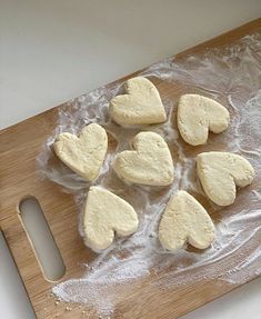 six heart shaped cookies on a wooden cutting board