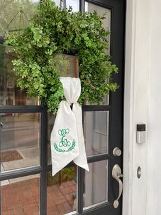 a door hanger with a monogrammed wreath hanging on it's front door