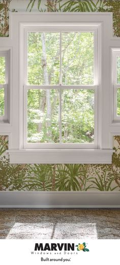 an empty room with green wallpaper and white window panes that are open to the trees outside