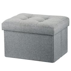 a grey ottoman with buttons on the top and bottom, sitting in front of a white background