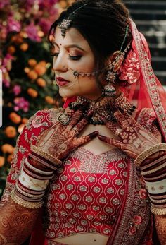 a woman in a red and white bridal outfit with her hands on her chest