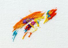 an image of colorful paint splattered on the white paper that has been drawn with colored crayons