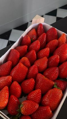 a box full of strawberries sitting on top of a table