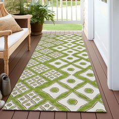 a green and white rug sitting on top of a wooden floor next to a door