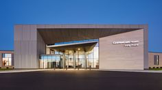 the front entrance to a large building with glass doors