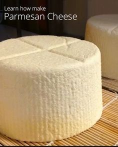 two cheeses sitting on top of a bamboo mat with the words learn how to make parmesan cheese