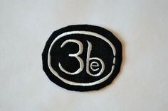 a black and white patch with the number thirty three in it's center on a white surface