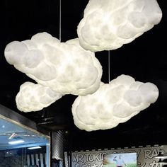 three white clouds hanging from the ceiling in a restaurant