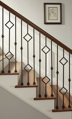 a set of stairs with metal railings and wood handrails in a home